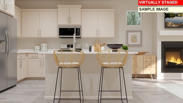 kitchen with a lit fireplace, white cabinetry, stainless steel refrigerator with ice dispenser, and stove