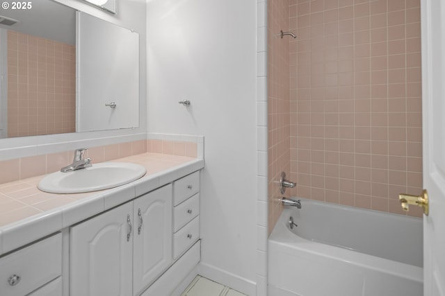 bathroom featuring vanity, tile patterned flooring, and tiled shower / bath