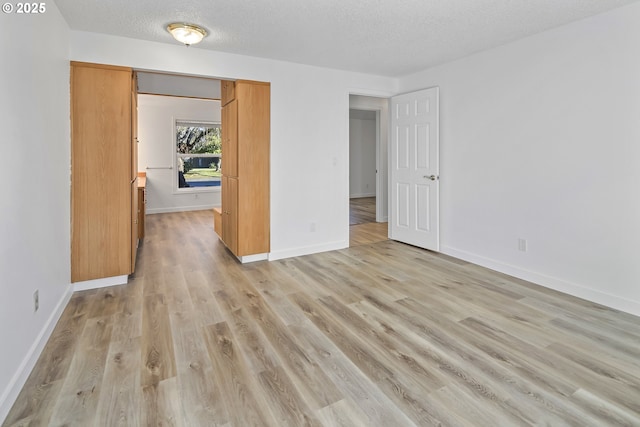 unfurnished bedroom featuring a textured ceiling and light hardwood / wood-style floors