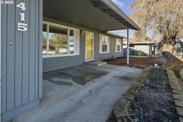 view of exterior entry with a patio area