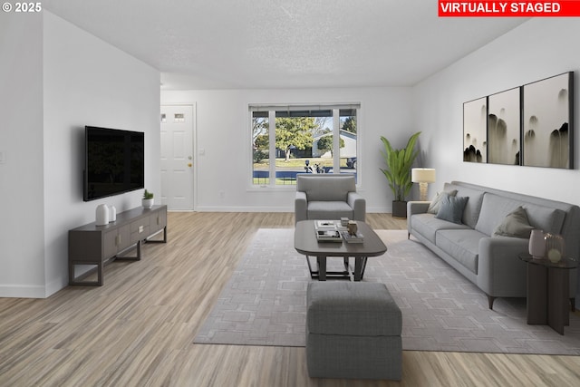 living room with light hardwood / wood-style floors and a textured ceiling