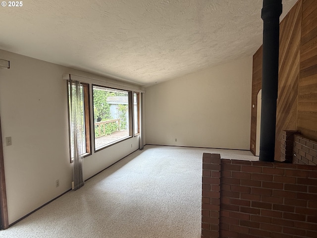 2040 40th St, Florence, OR 97439 - empty room featuring a textured ceiling, light colored carpet, and a wood stove