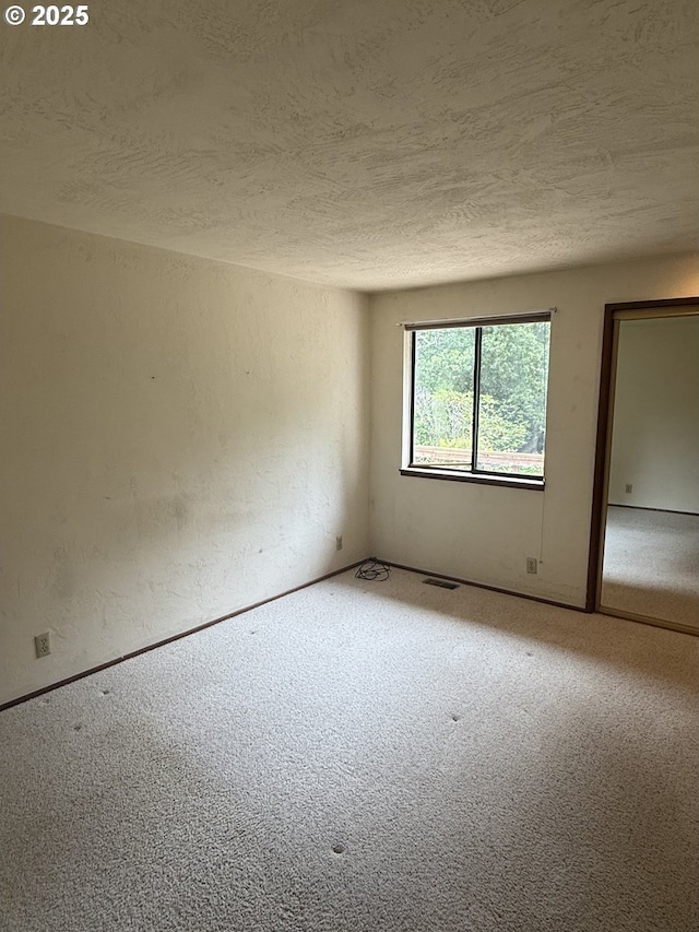 2040 40th St, Florence, OR 97439 - unfurnished room featuring a textured ceiling, carpet floors, and a textured wall