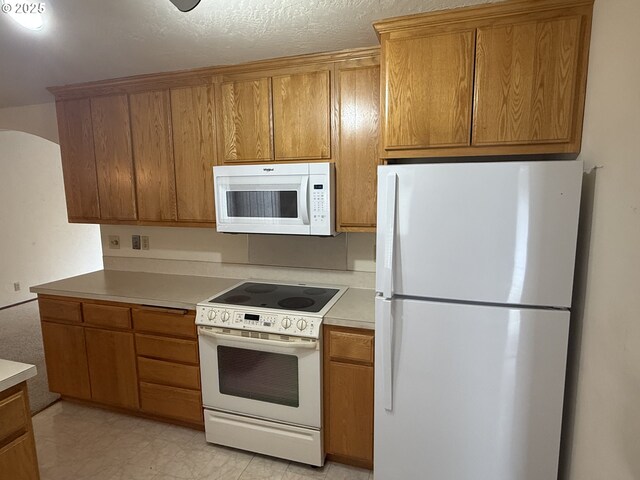 2040 40th St, Florence, OR 97439 - kitchen featuring white appliances, brown cabinetry, and light countertops