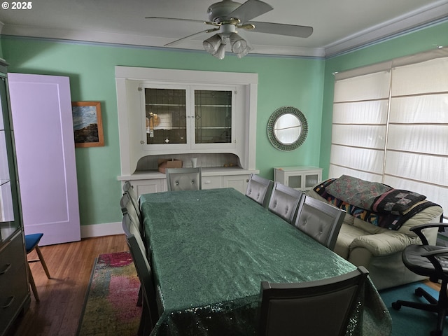 dining space with crown molding, dark hardwood / wood-style floors, and ceiling fan