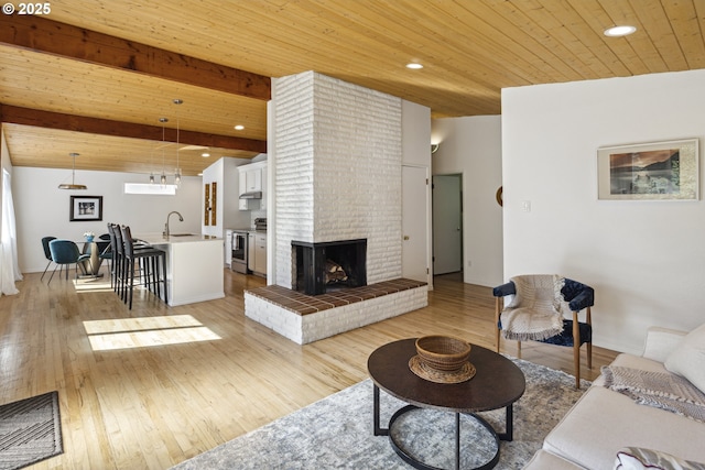 living room with wood ceiling, light wood-style floors, recessed lighting, and a fireplace