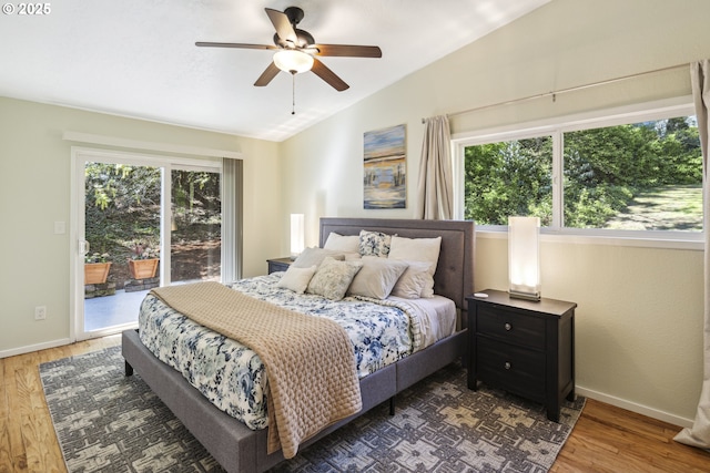 bedroom featuring lofted ceiling, access to outside, multiple windows, and wood finished floors
