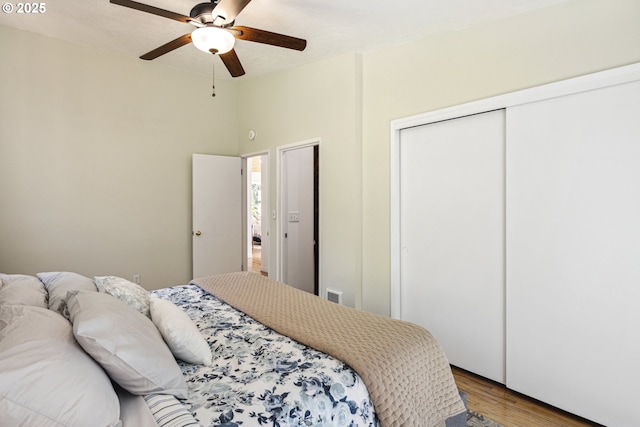 bedroom with wood finished floors, a ceiling fan, and a closet