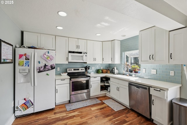 1612 12th St, Oregon City, OR 97045 - kitchen featuring appliances with stainless steel finishes, white cabinets, light wood-style floors, light countertops, and recessed lighting