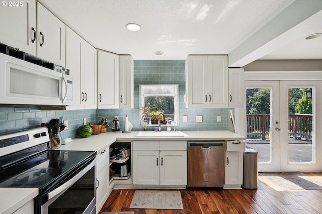 1612 12th St, Oregon City, OR 97045 - kitchen with appliances with stainless steel finishes, french doors, dark wood-type flooring, decorative backsplash, and light countertops