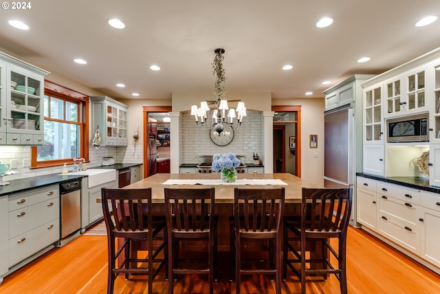 dining space with light wood-type flooring, recessed lighting, and an inviting chandelier