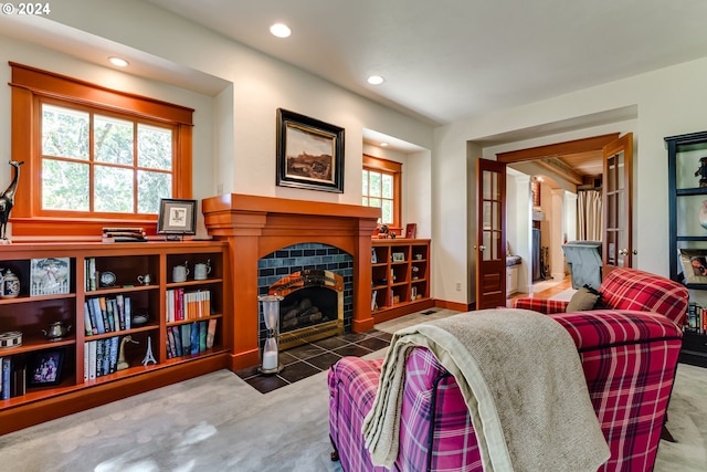 carpeted living area with a tile fireplace, a healthy amount of sunlight, and recessed lighting
