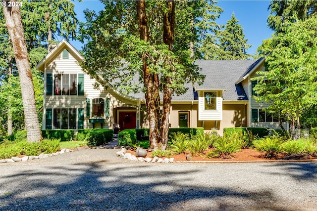 view of front of property with driveway and roof with shingles
