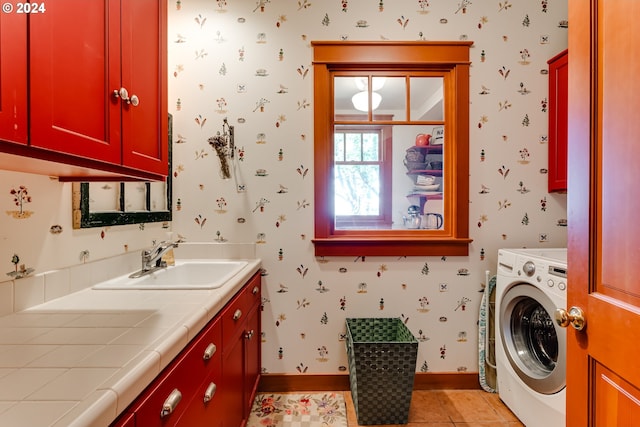 laundry room with baseboards, wallpapered walls, a sink, washer / dryer, and cabinet space