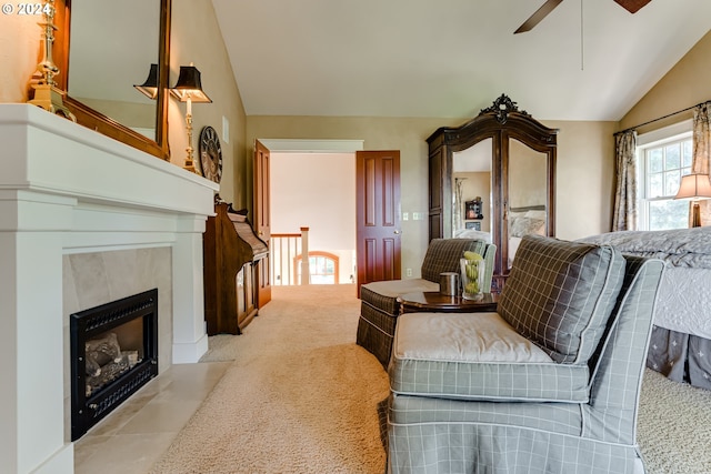 living area featuring a fireplace with flush hearth, light colored carpet, vaulted ceiling, and ceiling fan