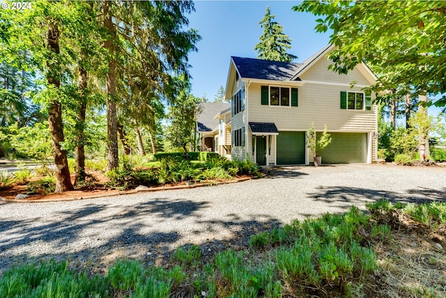 view of front of home with gravel driveway and a garage