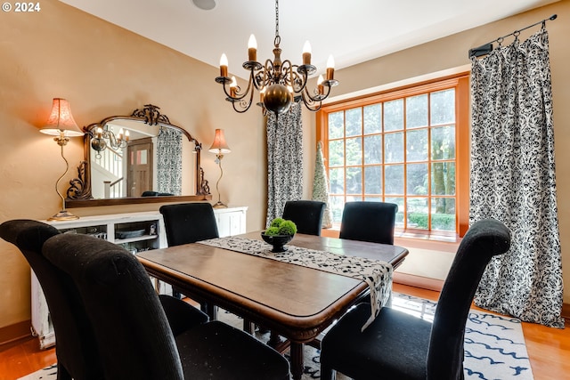 dining room featuring wood finished floors and an inviting chandelier