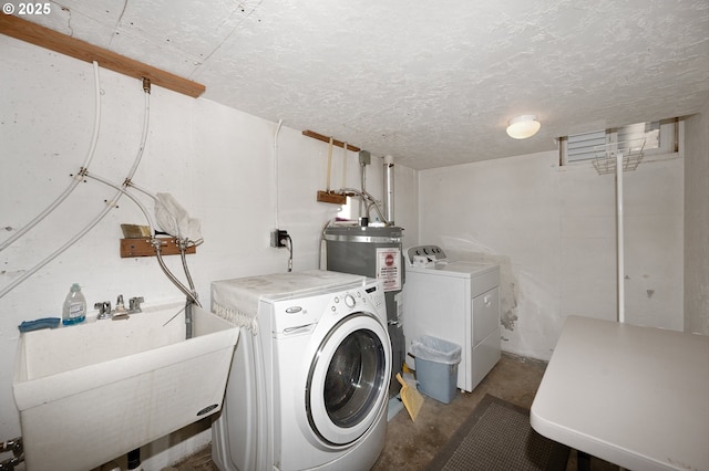 laundry area with separate washer and dryer, sink, and a textured ceiling