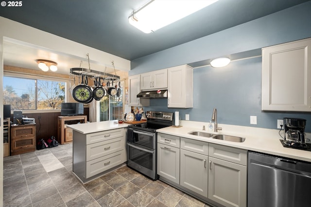 kitchen featuring stainless steel appliances, white cabinetry, sink, and kitchen peninsula