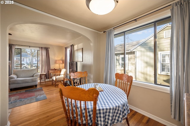 dining area with ornamental molding and hardwood / wood-style floors