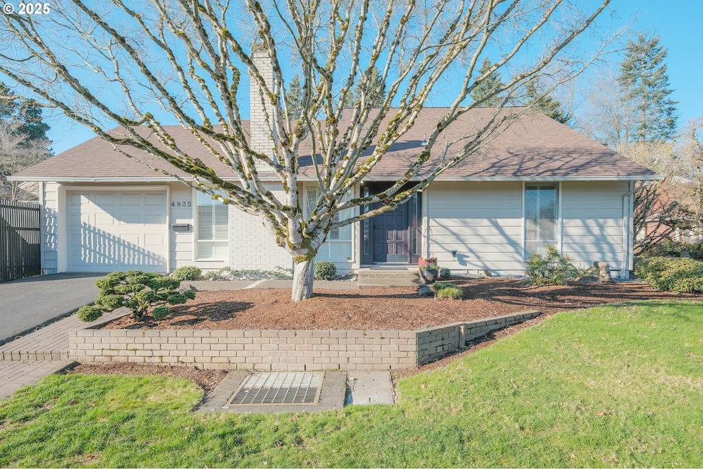 view of front of house featuring a garage and a front lawn