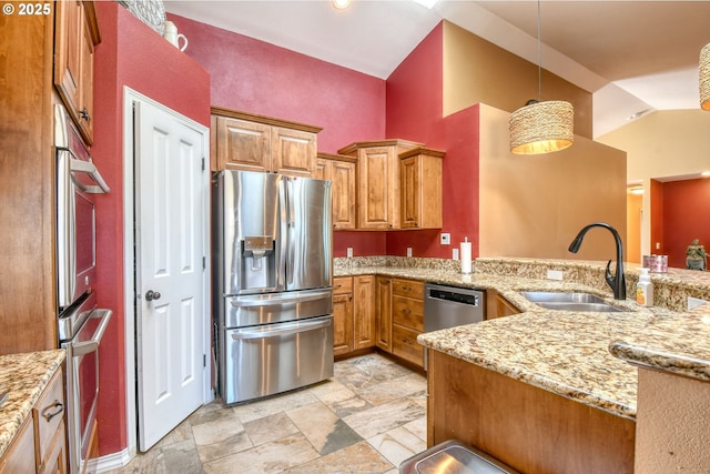 755 NW 23rd St, Pendleton, OR 97801 - kitchen with stainless steel appliances, brown cabinets, light stone countertops, decorative light fixtures, and vaulted ceiling