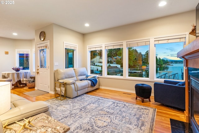 living room featuring light wood finished floors, recessed lighting, and baseboards