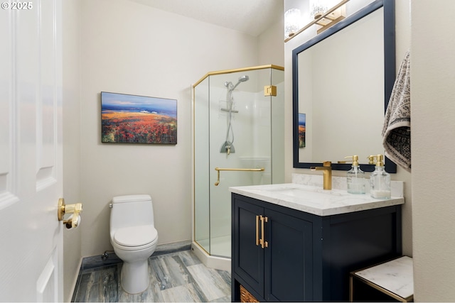 bathroom featuring a shower stall, toilet, wood finished floors, and vanity