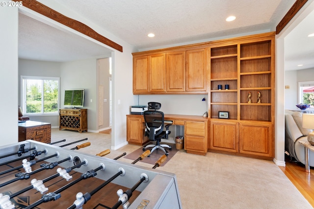 office featuring built in desk, plenty of natural light, baseboards, recessed lighting, and a textured ceiling