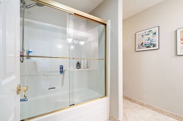 bathroom featuring enclosed tub / shower combo, baseboards, and tile patterned floors