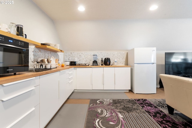 kitchen featuring freestanding refrigerator, wall oven, decorative backsplash, white cabinetry, and recessed lighting