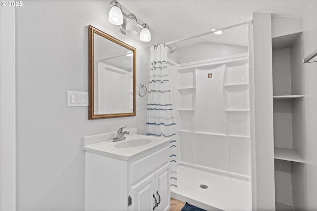 bathroom featuring walk in shower and vanity