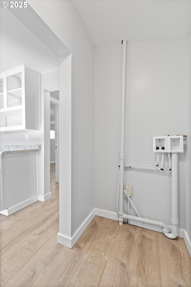 washroom with washer hookup and light hardwood / wood-style flooring