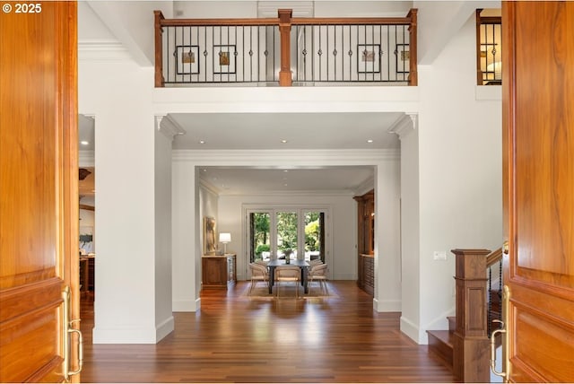 foyer entrance featuring stairway, ornamental molding, baseboards, and wood finished floors