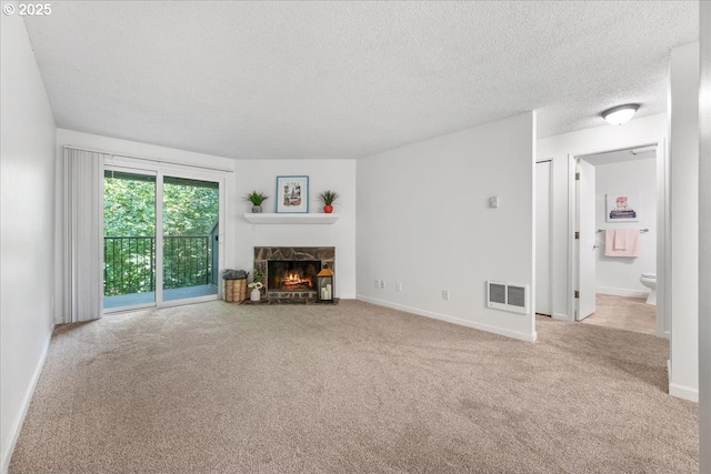 12618 NW Barnes Rd Unit 11, Portland, OR 97229 - unfurnished living room featuring carpet floors, a stone fireplace, and a textured ceiling