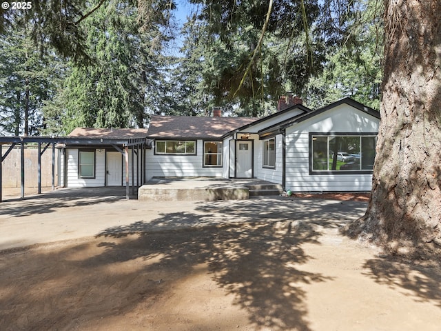 3241 SE 150th Ave, Portland, OR 97236 - view of front facade with concrete driveway, a chimney, and a carport