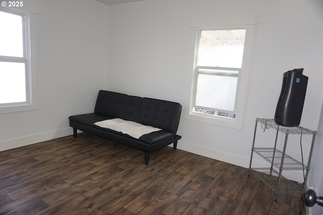 sitting room with dark wood finished floors and baseboards