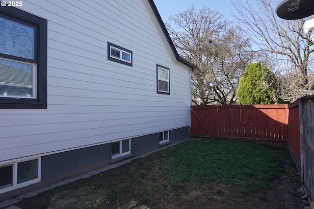 view of side of home featuring a fenced backyard and a yard