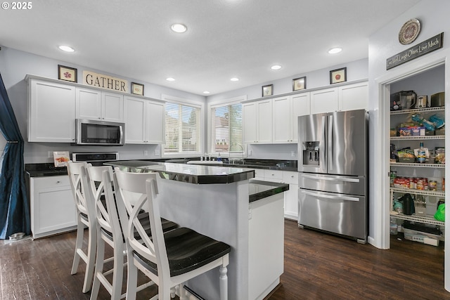 3801 NE 93rd St, Vancouver, WA 98665 - kitchen featuring dark wood-type flooring, white cabinets, dark countertops, and stainless steel appliances