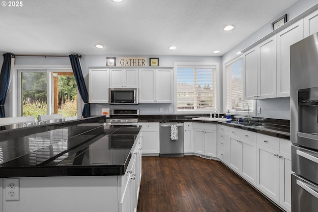 3801 NE 93rd St, Vancouver, WA 98665 - kitchen with dark countertops, dark wood-style floors, white cabinetry, and appliances with stainless steel finishes