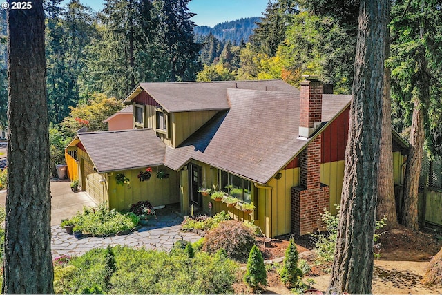 2323 Todd St, Eugene, OR 97405 - view of front of house featuring board and batten siding, a chimney, roof with shingles, a garage, and a view of trees
