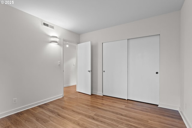 unfurnished bedroom featuring visible vents, baseboards, and light wood finished floors