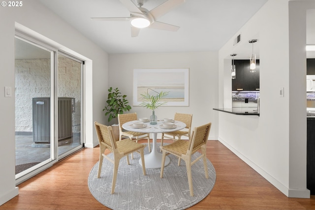 dining area featuring visible vents, ceiling fan, baseboards, and wood finished floors