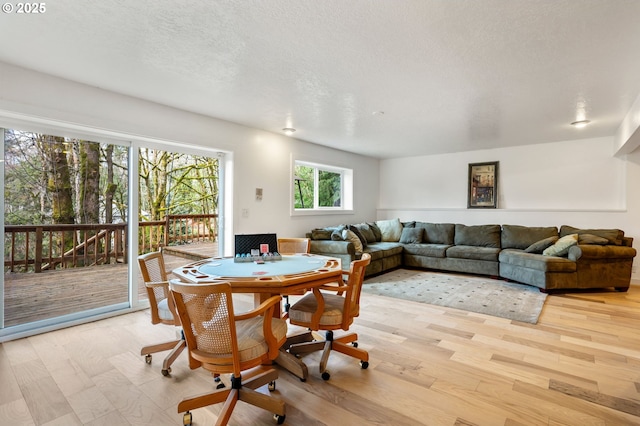 dining room with light wood-style floors and a textured ceiling