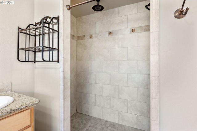 full bath with tiled shower and vanity