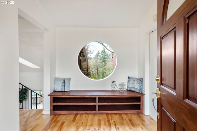 foyer with light wood-type flooring and a skylight