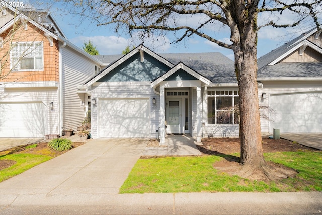 view of front of property with concrete driveway, a shingled roof, and an attached garage