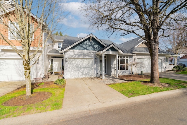 view of front facade with roof with shingles, driveway, and an attached garage