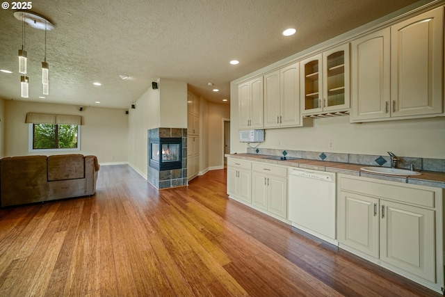 12033 S Shadow Hills Ct, Turner, OR 97392 - kitchen featuring white dishwasher, a sink, light wood-style flooring, open floor plan, and a textured ceiling