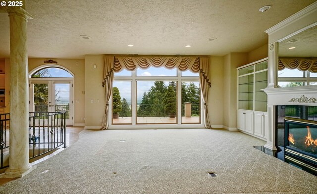 12033 S Shadow Hills Ct, Turner, OR 97392 - unfurnished living room featuring a textured ceiling, carpet flooring, recessed lighting, a glass covered fireplace, and baseboards